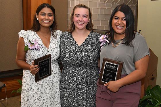 Photo of three smiling women holding awards